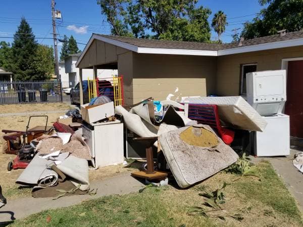 Front yard of a home full of junk